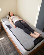 Woman relaxing on the Woojer MAT in a bright room