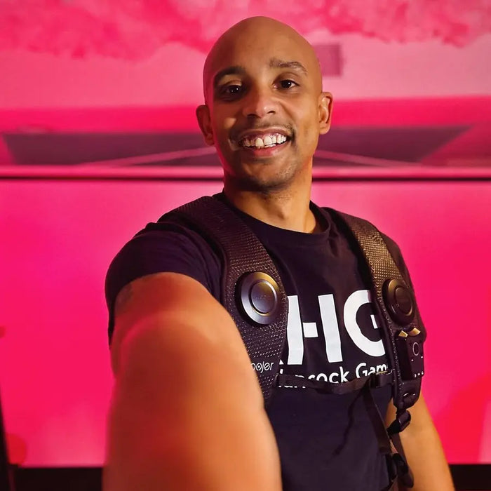 Woojer customer smiling in front of a pink wall
