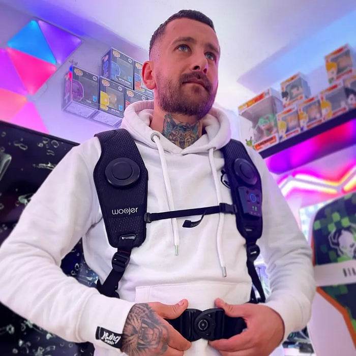 Customer gaming in a white hoodie wearing the Woojer Vest