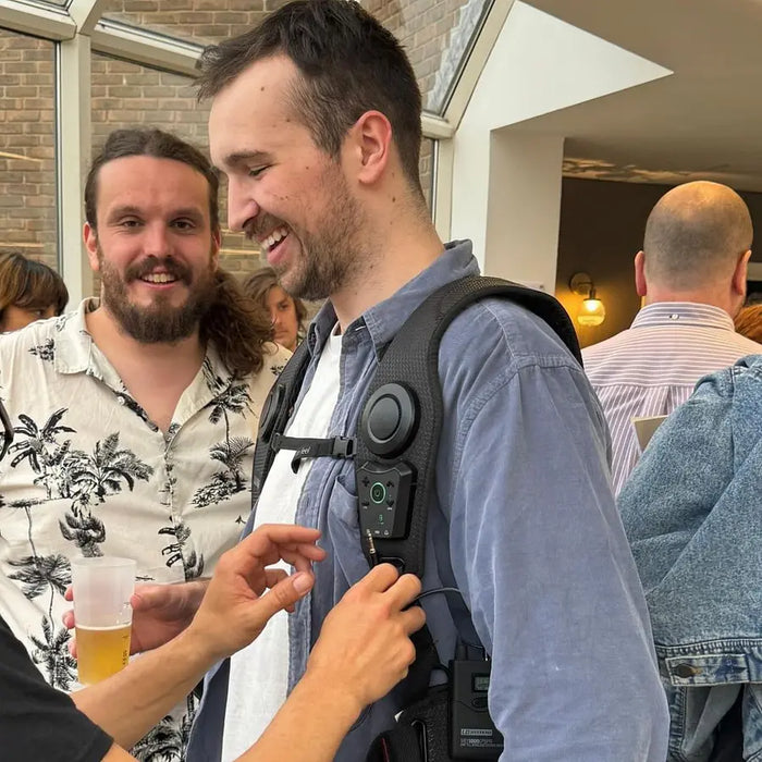 Two customers wearing Woojer Vests at a bar