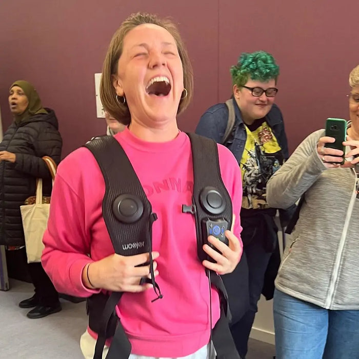 Customer in pink wearing the Woojer Vest at an event
